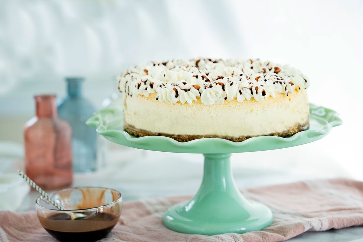 whole vanilla bean cheesecake on a cake stand