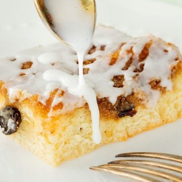 pouring glaze over cinnamon roll cake