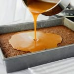 caramel being poured on the first layer baked of the oatmeal cake
