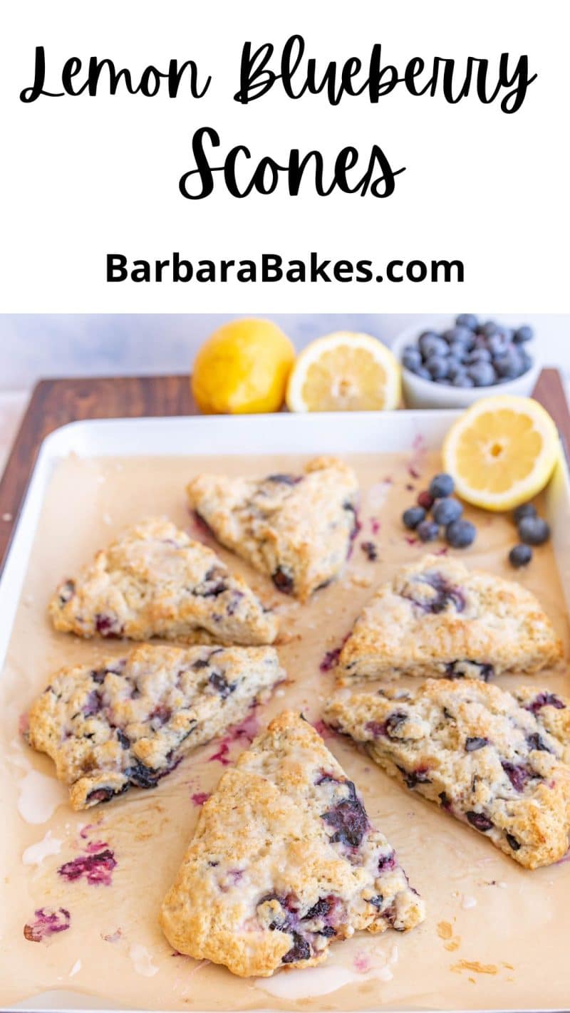 pin that reads "lemon blueberry scones" with an image of the scones, berries and citrus, and a light drizzle of icing cut on parchment paper