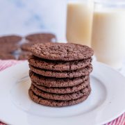 a neat stack or tower of chocolate thin brownie cookies on a white plate