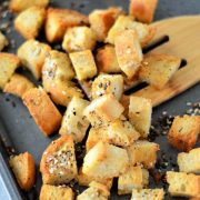 bread cubes on a baking sheet tossed in everything bagel seasoning