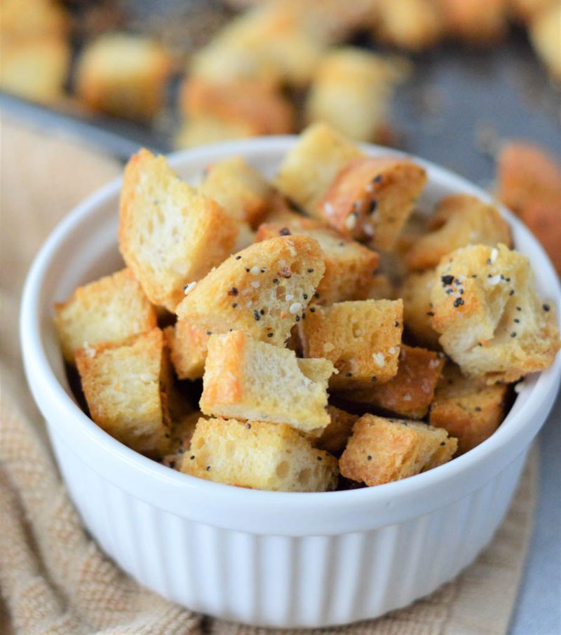everything bagel seasoned croutons in a small white dish