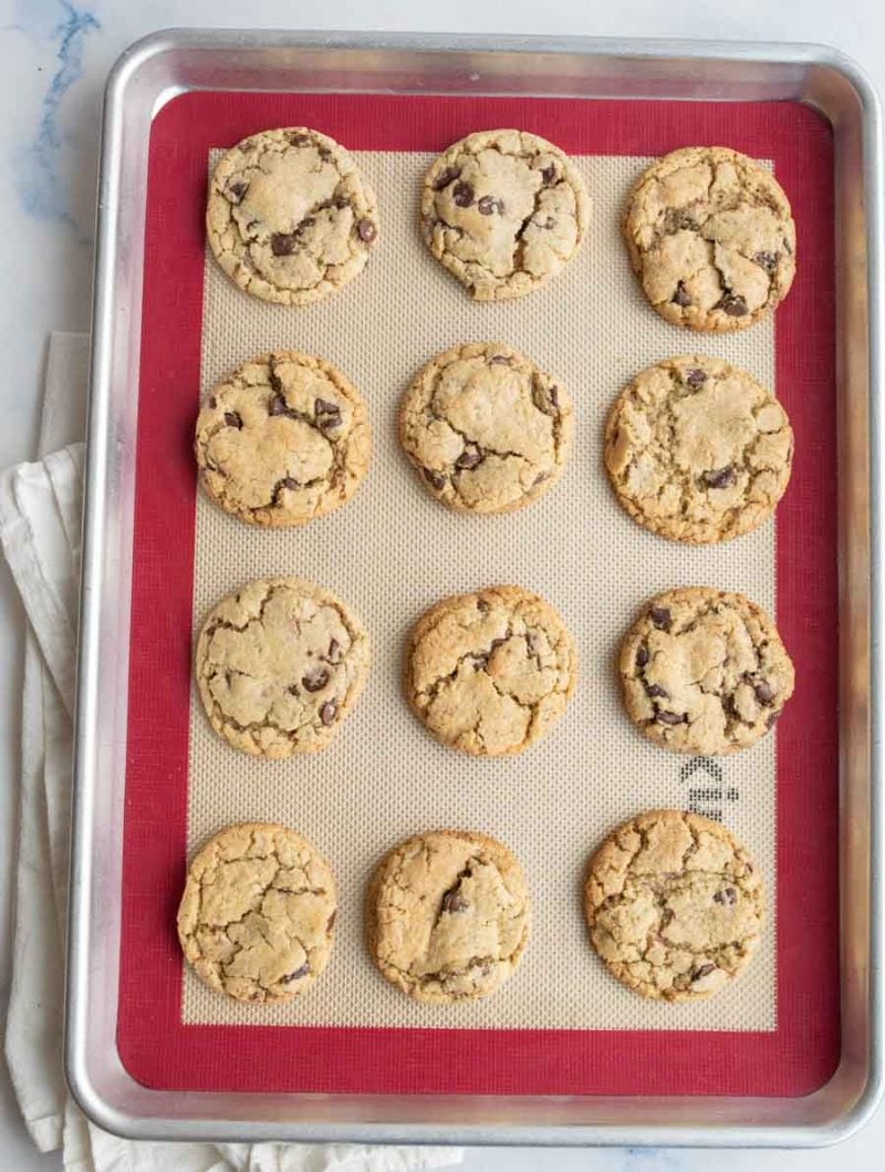 cracked top baked and neat rows of neiman marcus cookies on a silicone lined baking sheet