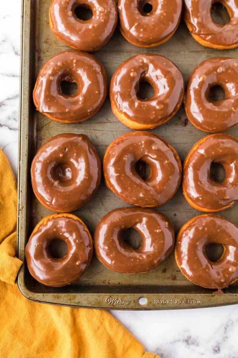 chocolate glazed donuts on a baking sheet