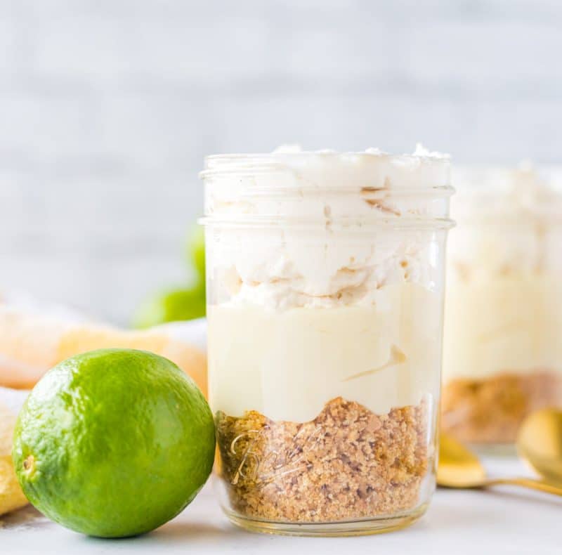 key lime pie in a mason jar with limes around it