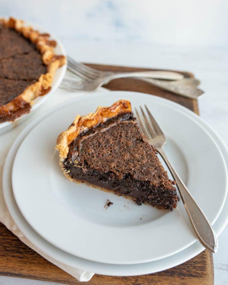 Slice of chocolate chess pie on a white plate