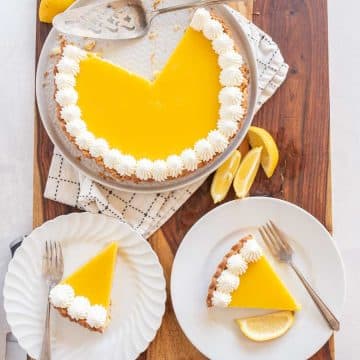 top view of lemon tart with two pieces served on two white plates