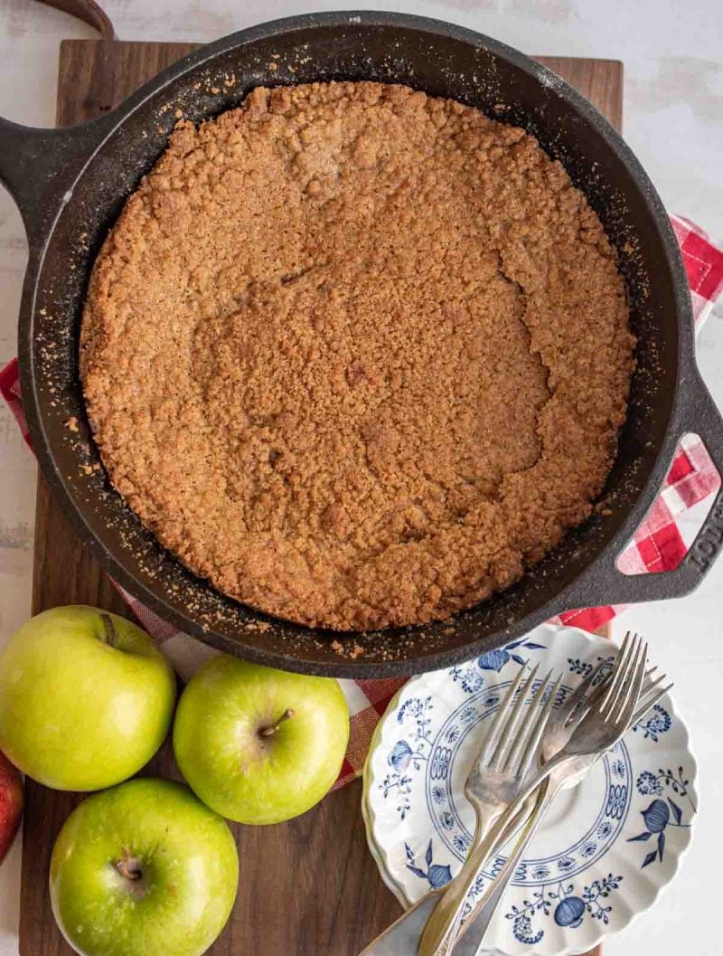 cast iron pan with whole apple crumble top view