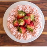 Beautiful display of strawberry buttercream and fresh strawberries on top of a cake