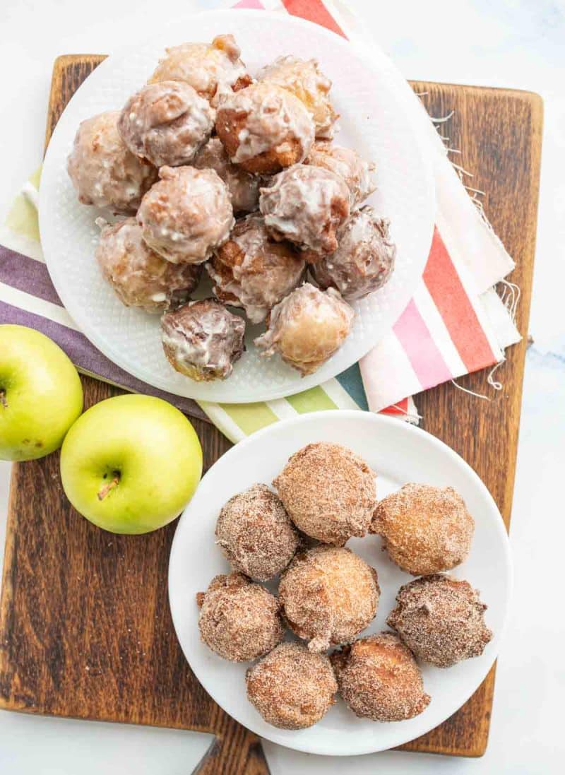 top view of iced and sugared apple fritters on a plate