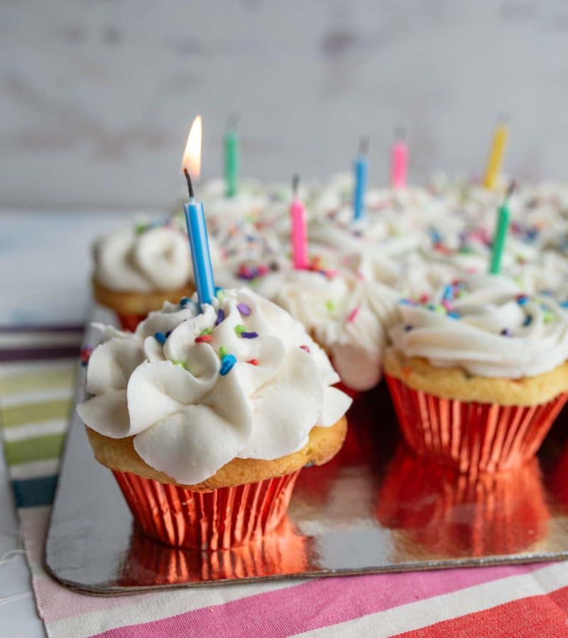 Birthday cupcakes with candles lit.