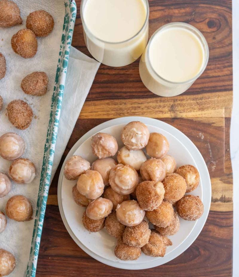 top view of a plate of round iced and sugar donut holes
