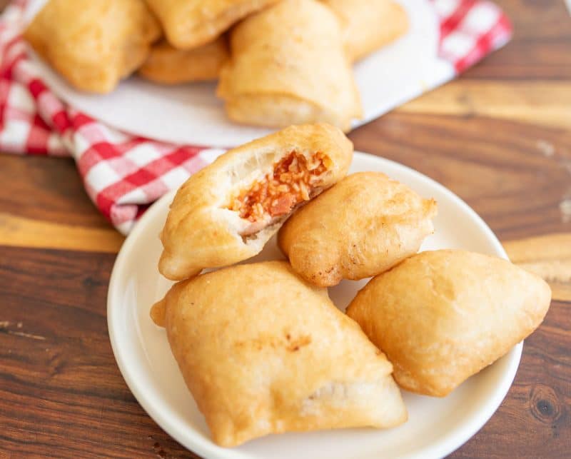 Finished pizza rolls on a white plate.