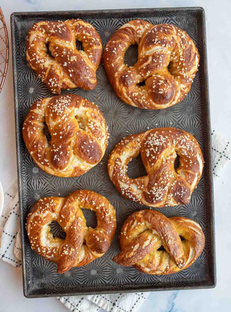 6 pretzels on a baking sheet.