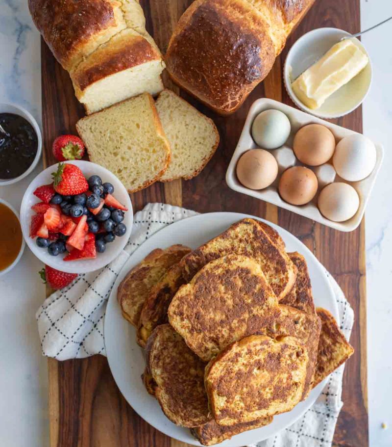 top aesthetic view of brioche french toast and eggs, berries and butter with jam