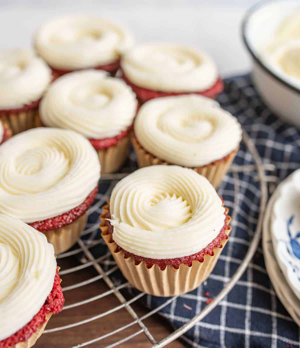 cooling rack with red velvet cupcakes and cream cheese frosting
