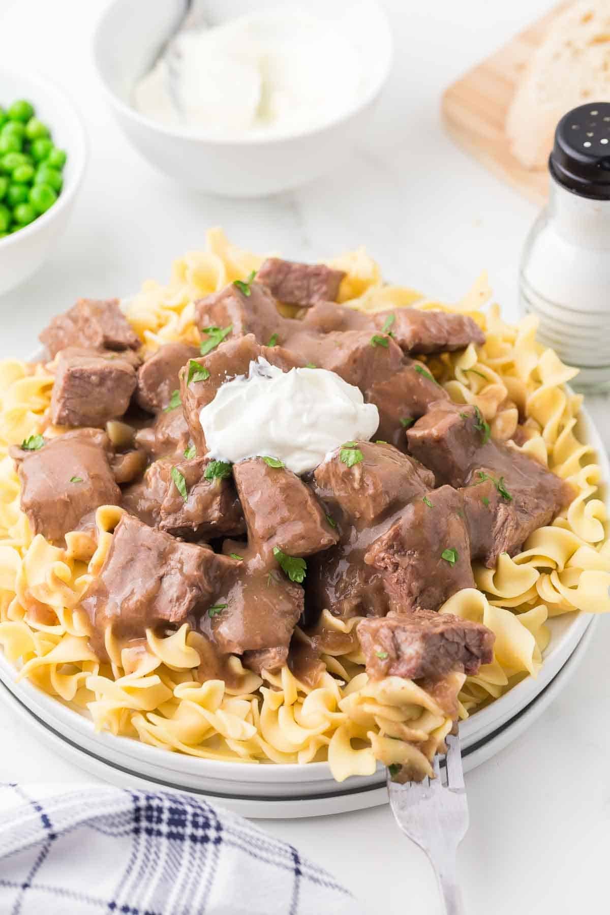plate of round steak beef and noodles recipe with sour cream in the middle